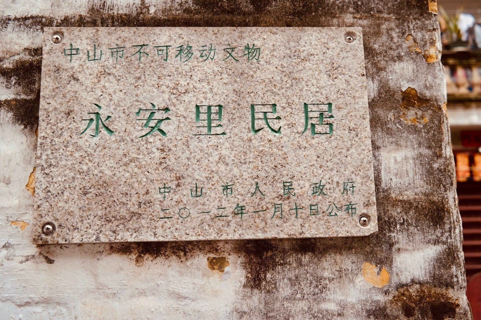 一块石牌上写着永安里民居于2012年列为中山市不可移动文物