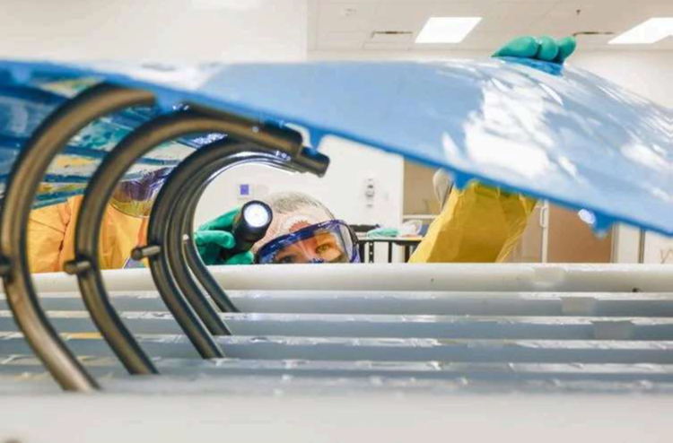 Participant checks under a conveyor belt during a Sanitation Essentials Training at CFS Institute North America. Amid food-related recalls, the trainers at Commercial Food Sanitation aim to help food companies worldwide keep their products as safe as possible.