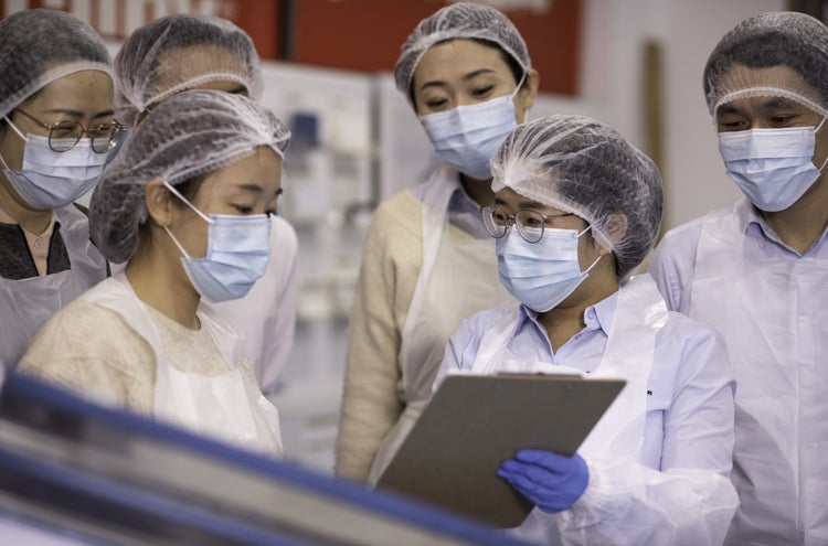 Workers masked and dressed in PPE