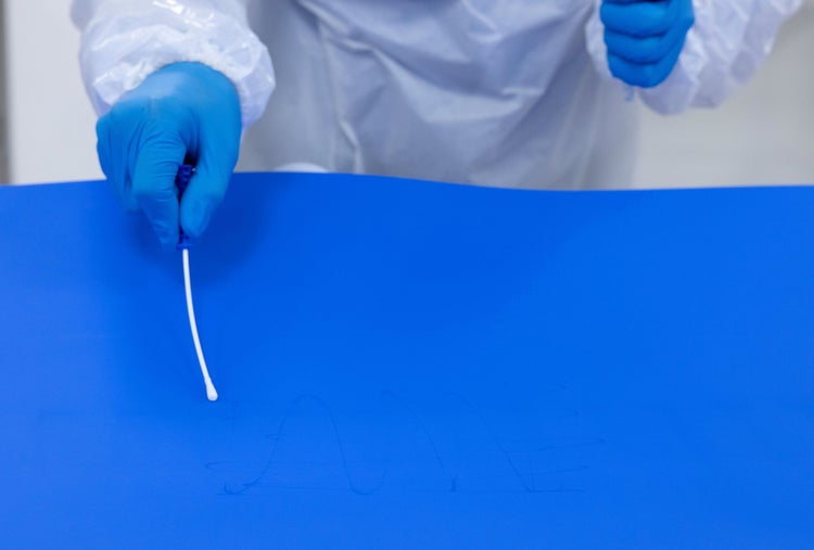Gloved hand taking a sterile sampling swab on a blue ThermoDrive belt