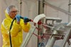 Man in PPE rinsing dirty conveyor