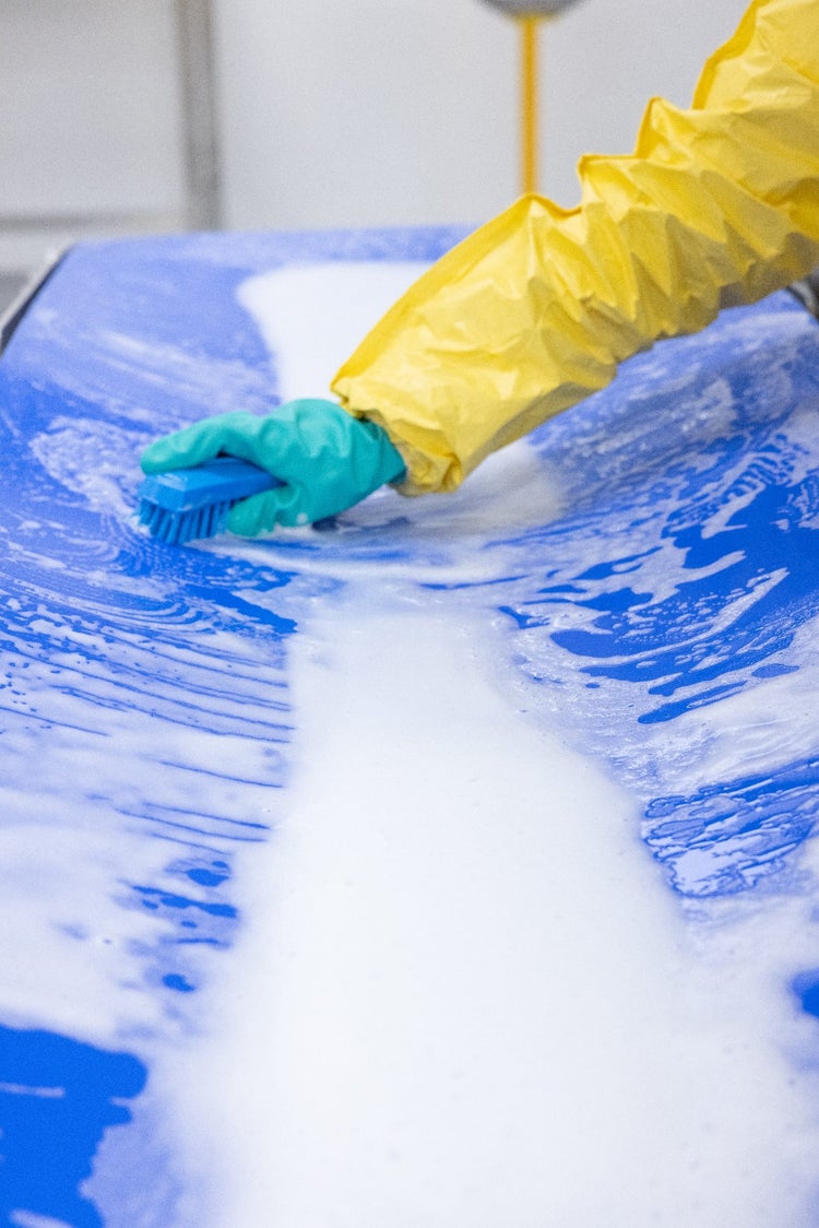 Wet cleaning with brush. Foam on blue belt. PPE