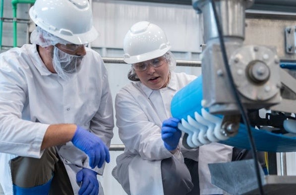 Two people inspecting a conveyor