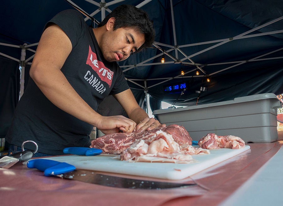 A man cutting meat on a cutting board