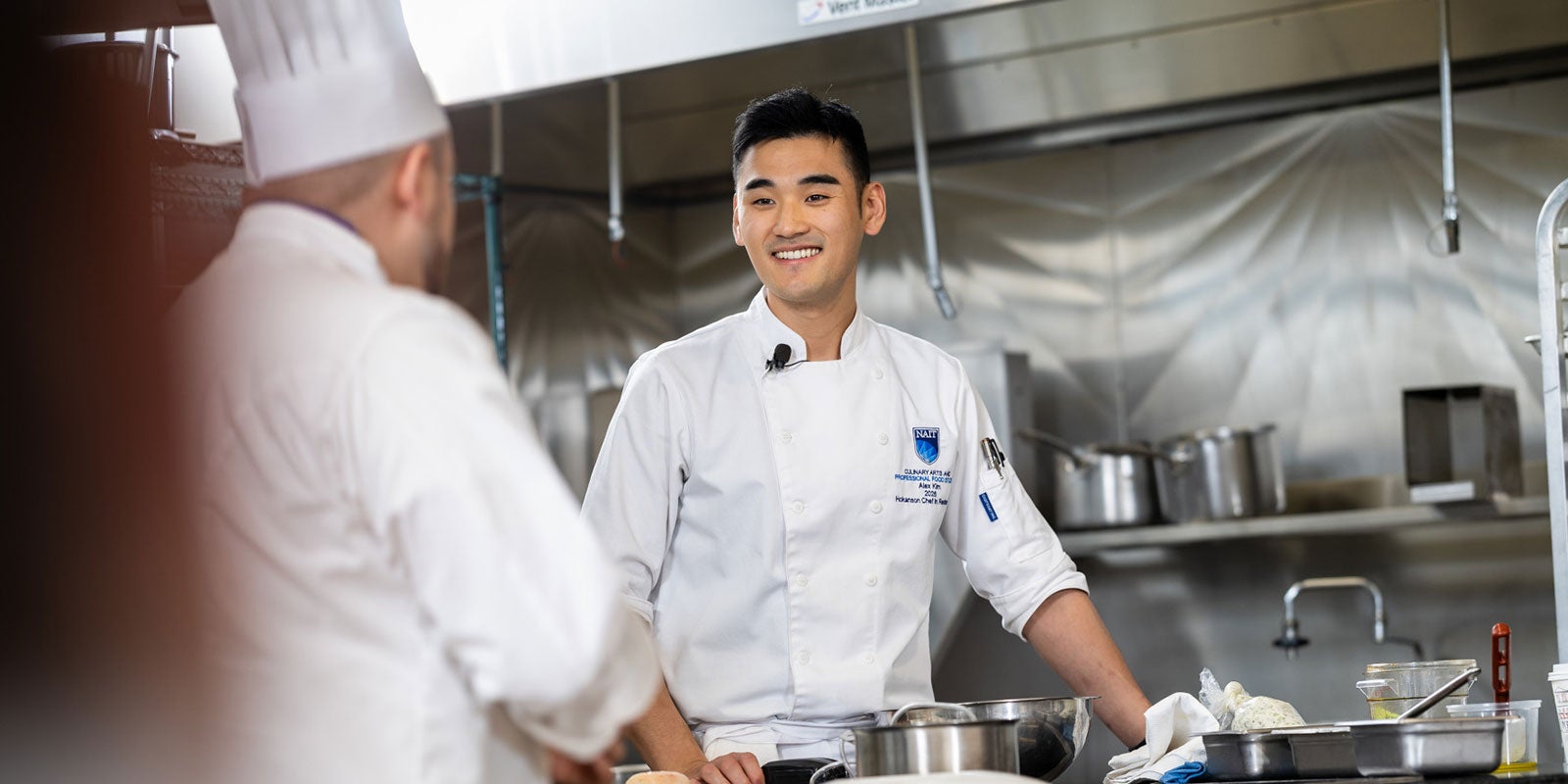 A man in a chef's uniform smiling A man in a chef's uniform smiling