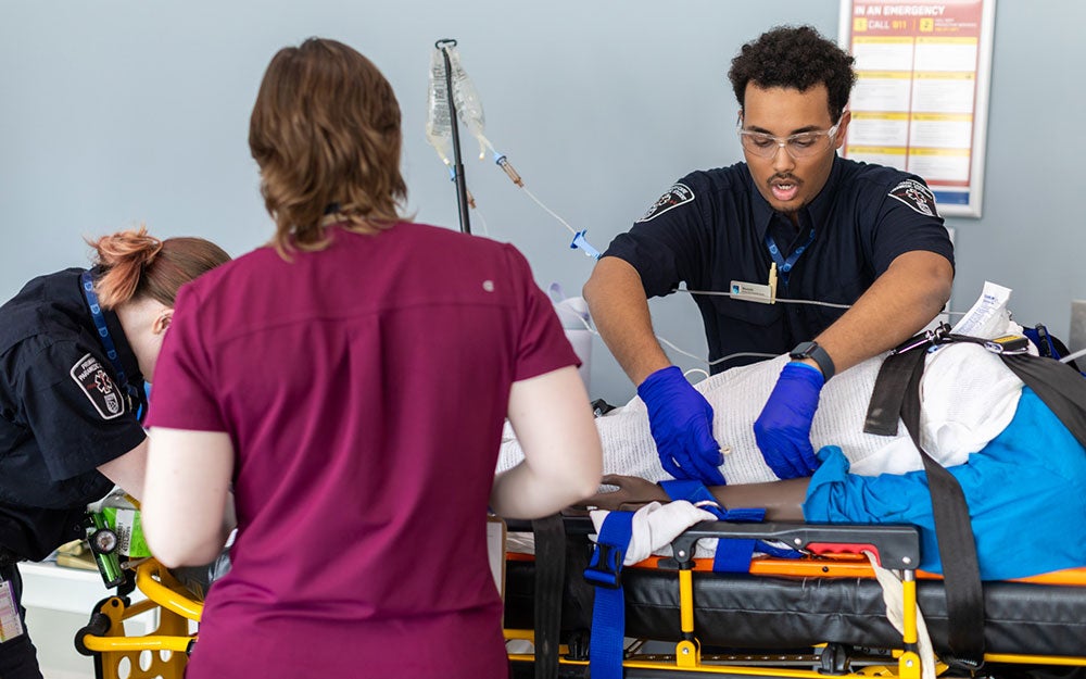 A man in a blue shirt and gloves working on a patient