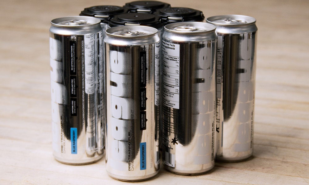 Multiple silver cans of League nutrition drink, including blue raspberry flavor, arranged in a cluster on a light wooden surface.