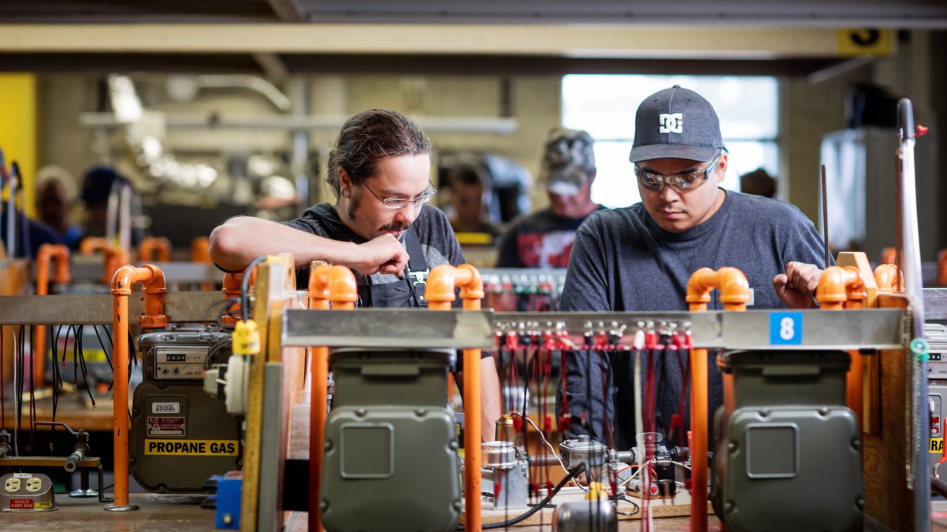 Two men at a gasfitter classroom workstation. Two men at a gasfitter classroom workstation.