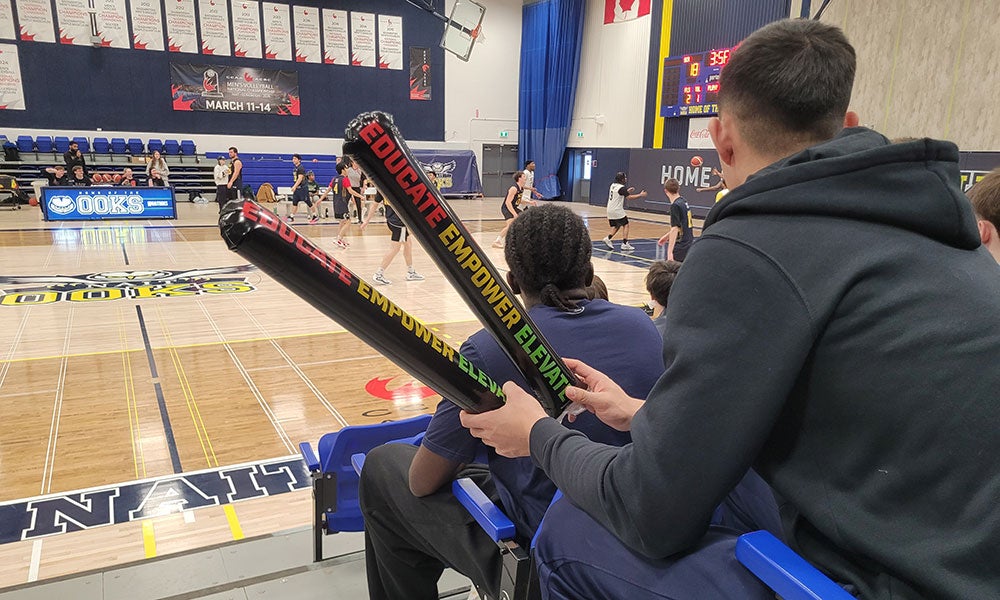 A man holding inflatable tubes in a gym