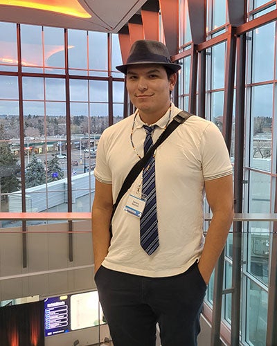 A man wearing a tie and a hat