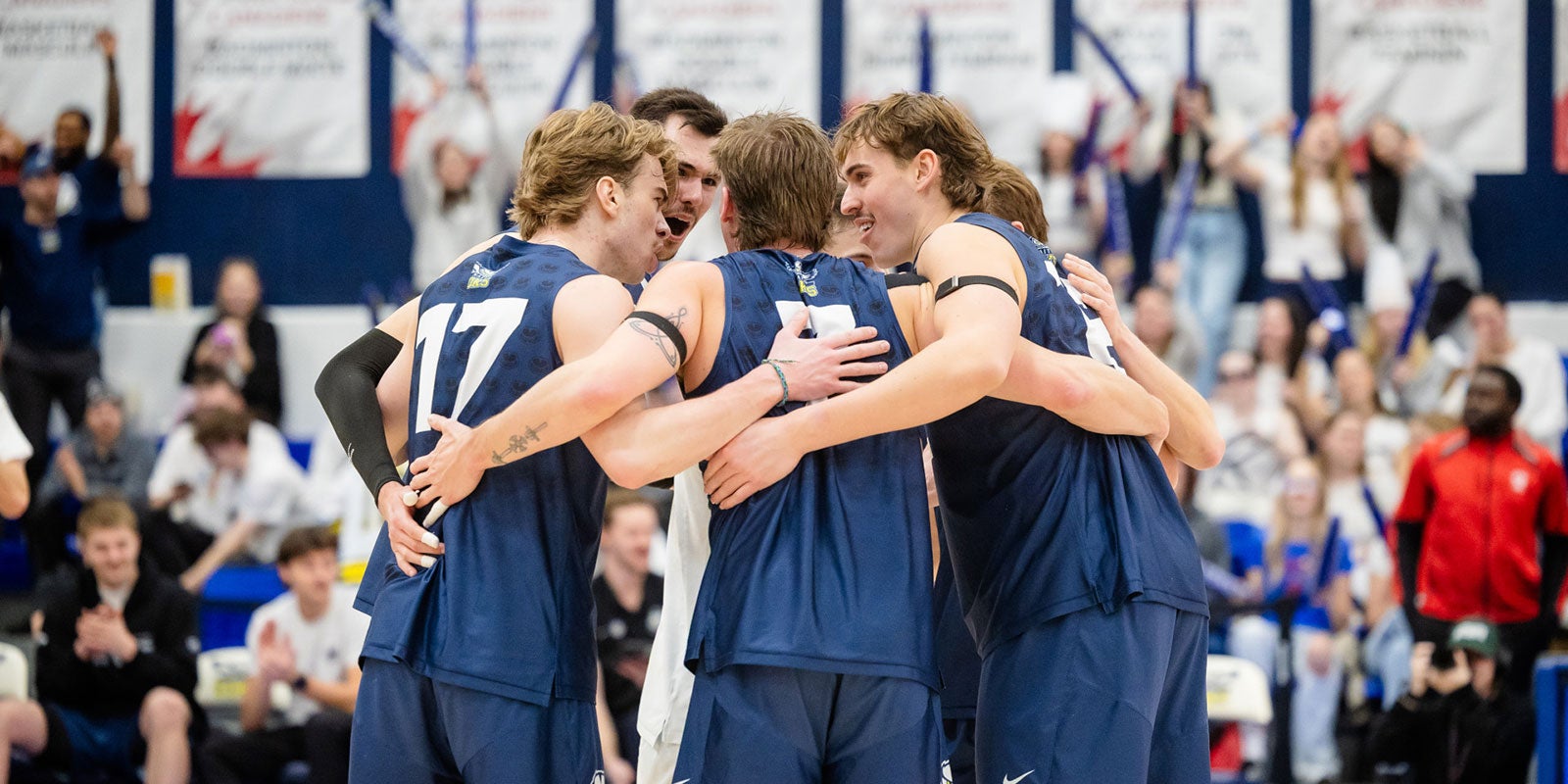 A group of men in blue uniforms hugging A group of men in blue uniforms hugging