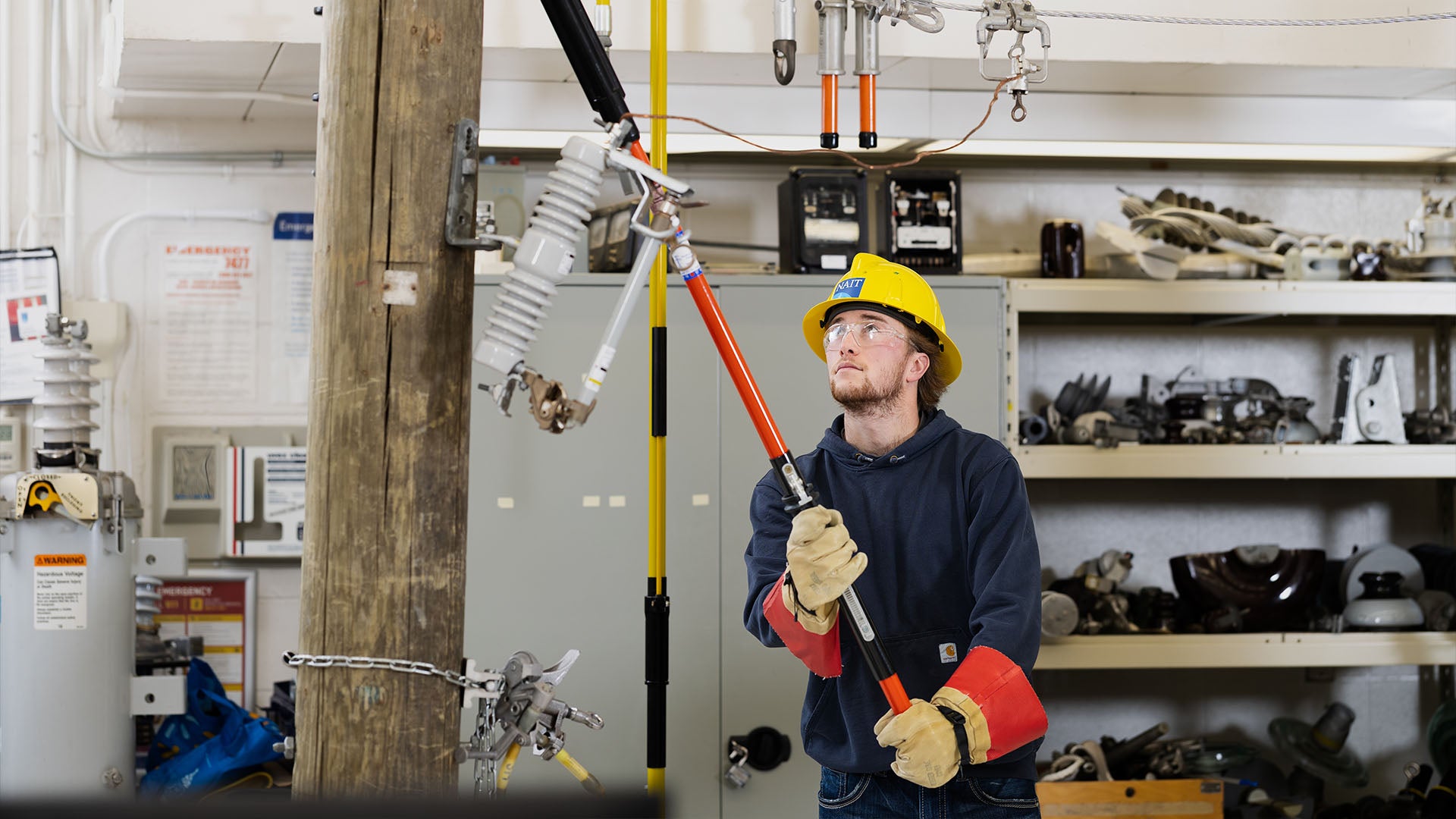 Powerline technician student wearing a hard hat and gloves in training Powerline technician student wearing a hard hat and gloves in training