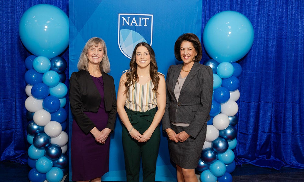 A group of women standing in front of a blue and white backdrop