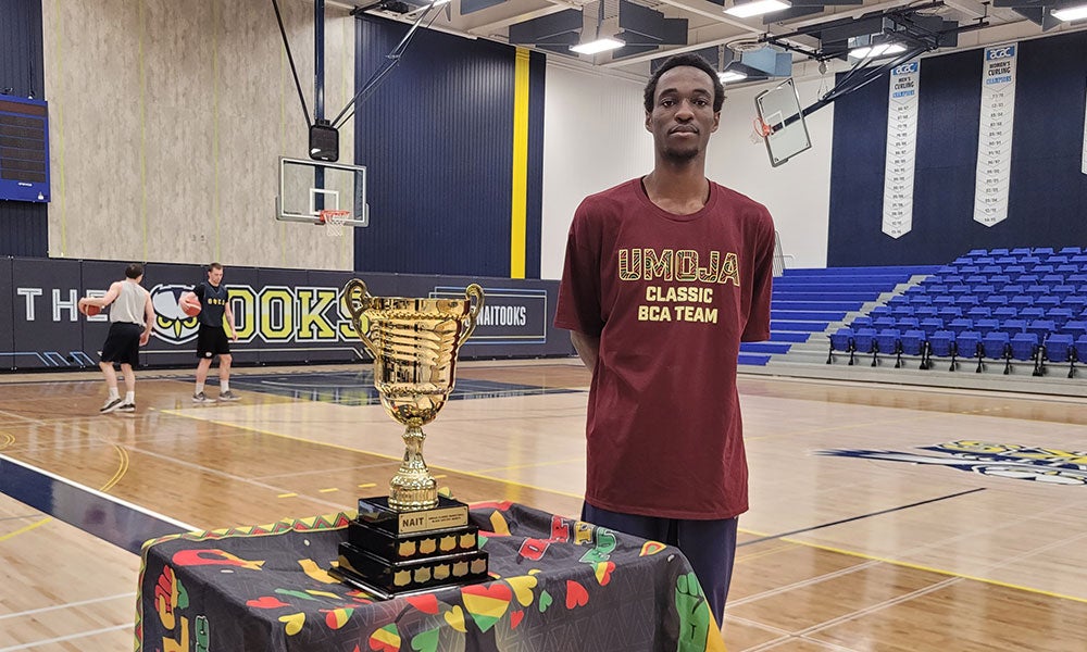 A man standing in front of a trophy