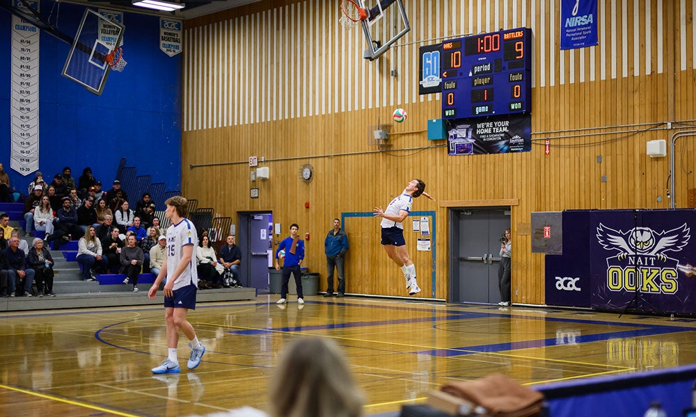 A man jumping in the air to hit a volleyball