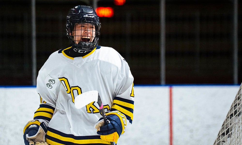 A hockey player in a white uniform and helmet