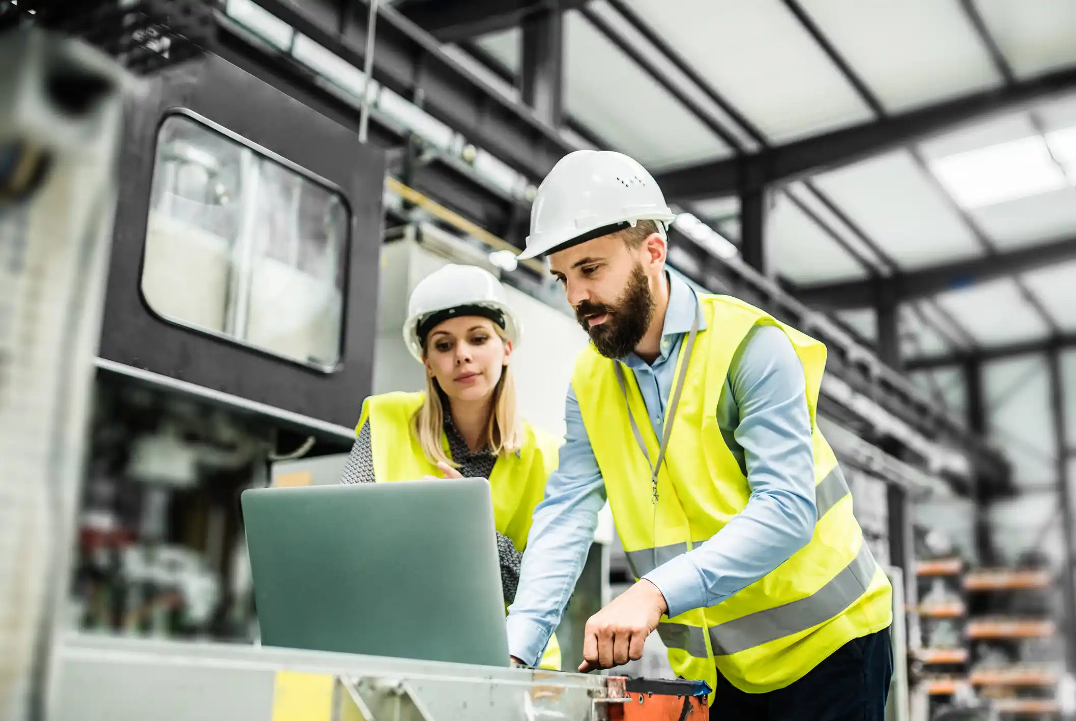 A portrait of two engineers with laptop in a factory