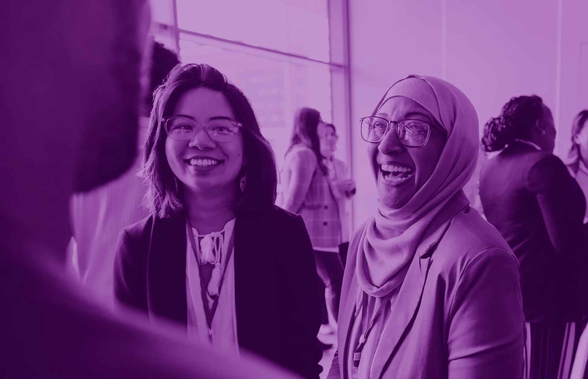 Female engineers at a conference smiling and talking