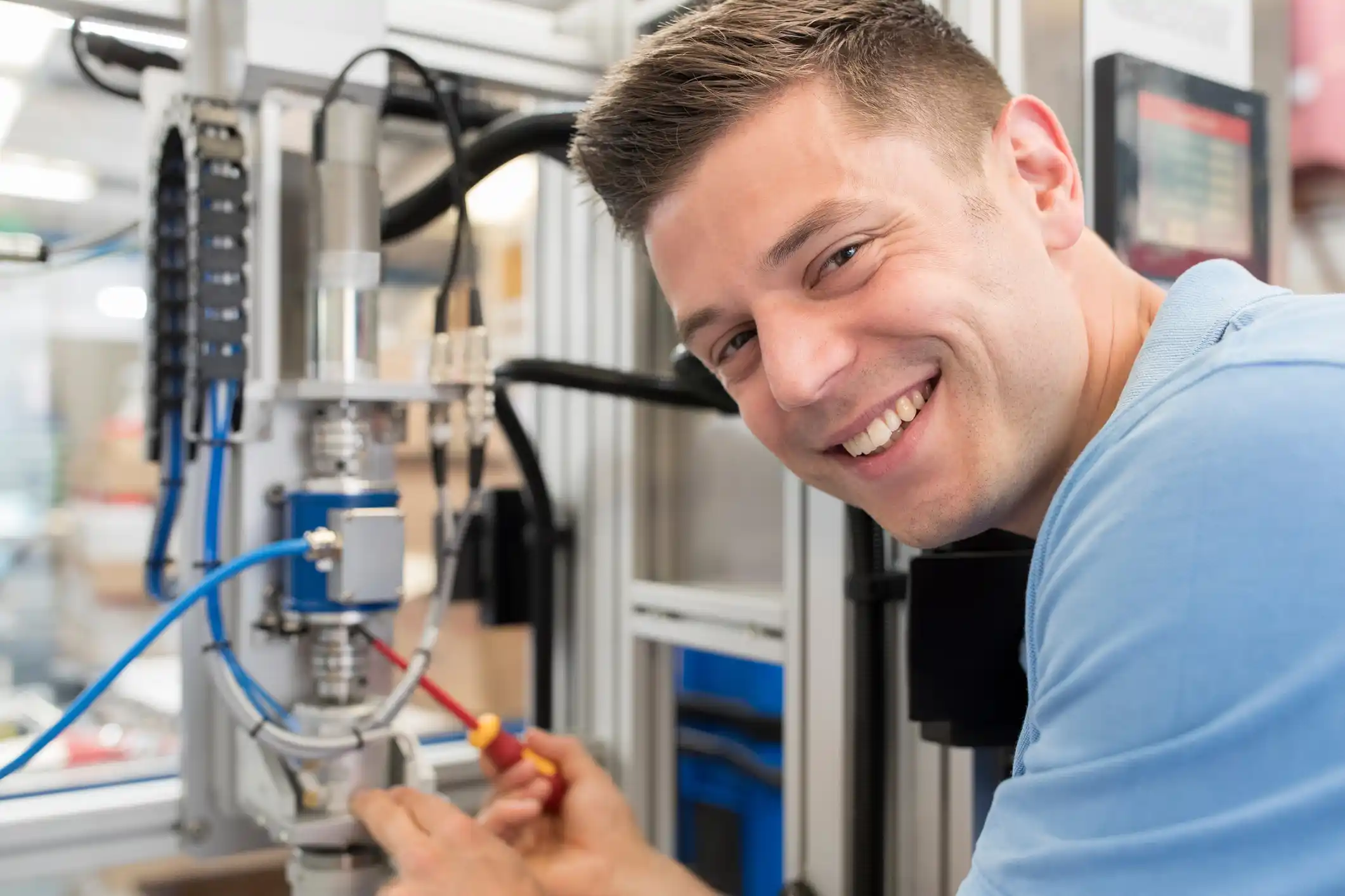 Engineering apprentice in a lab smiling