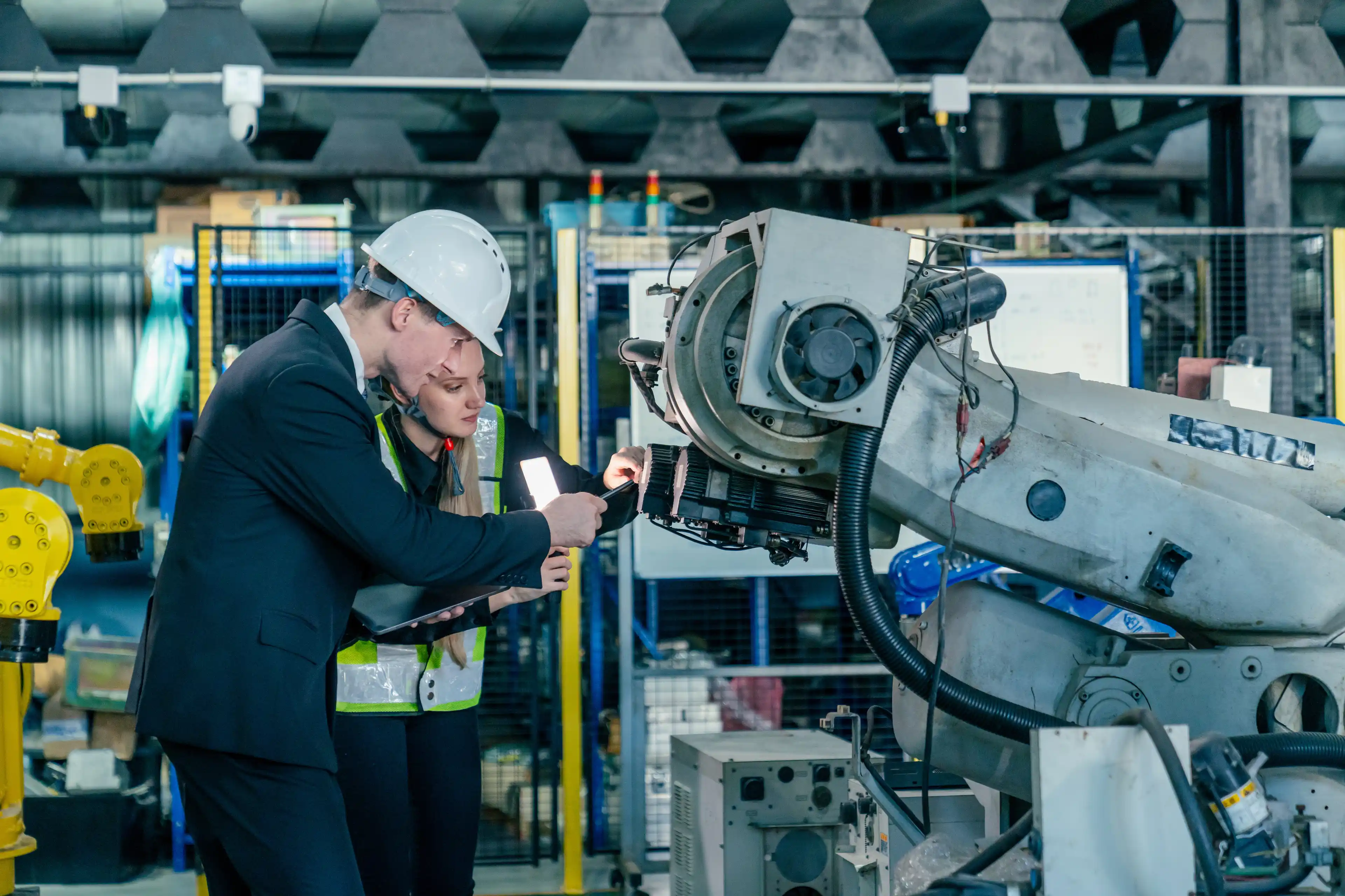 Mature businessman explaining new strategy plans to group of employees in a factory