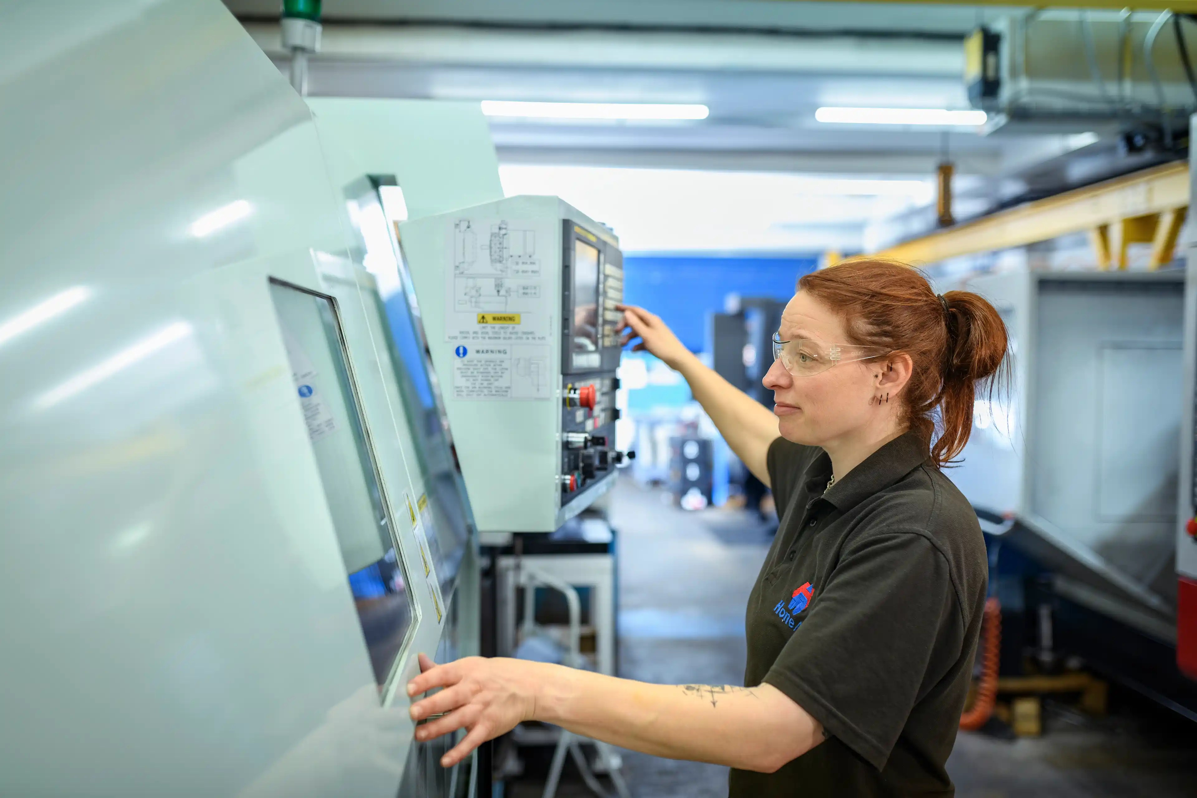 Woman in STEM working in an engineering facility with clear goggles.