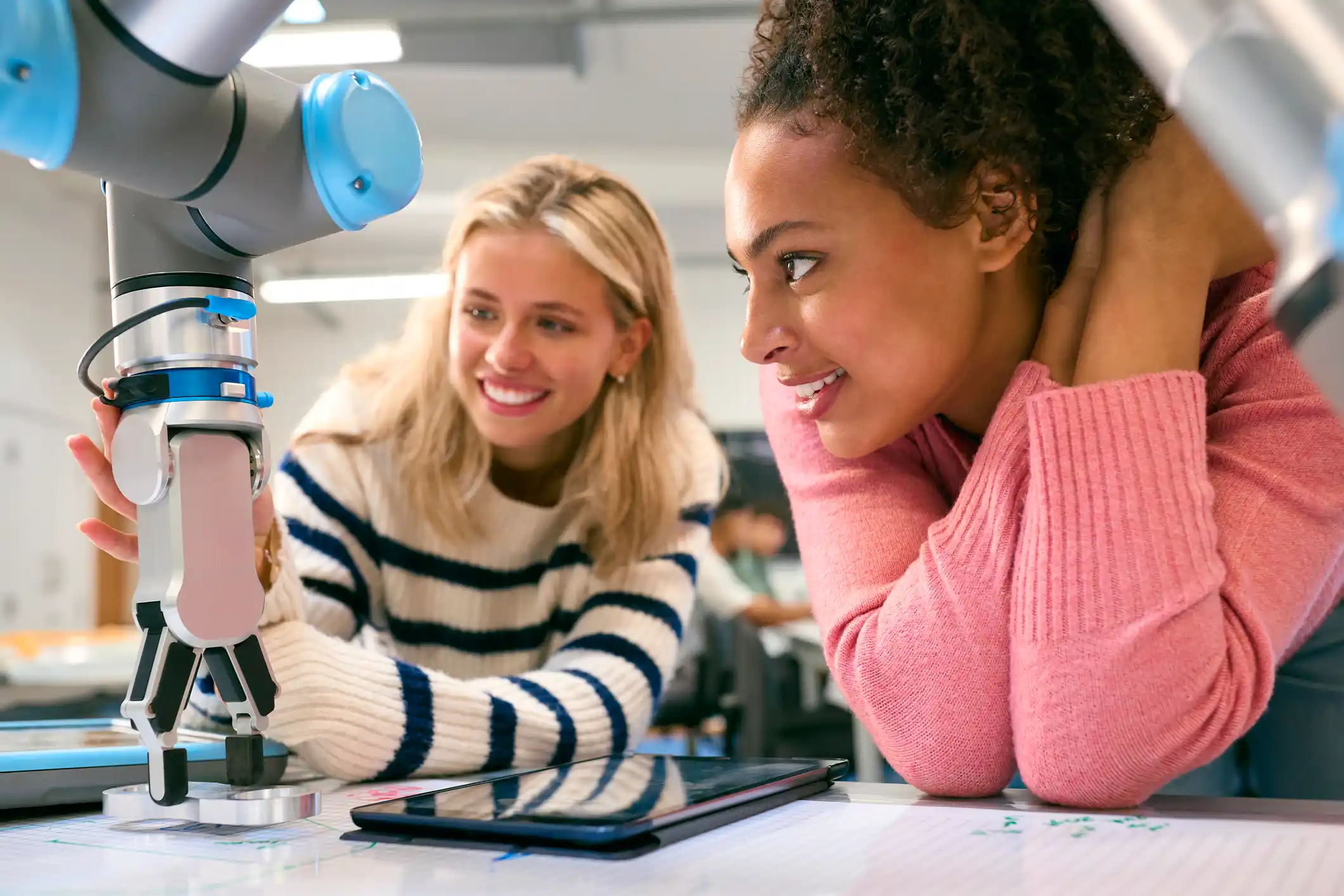 Two female engineering students in a lab working together on some specialist equipment