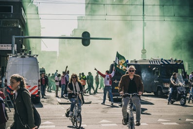 In de rook feest vierende voetbalsupporters met politie in de buurt