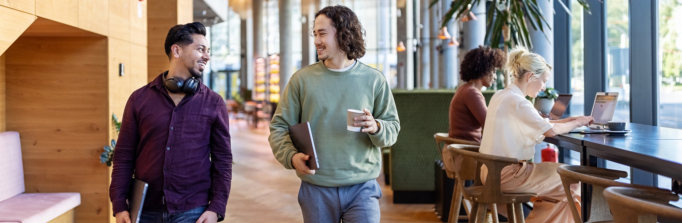 Collega's overleggen in een kantoor met werkende mensen op de achtergrond