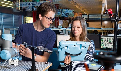 Twee studenten die een mechanisch probleem oplossen