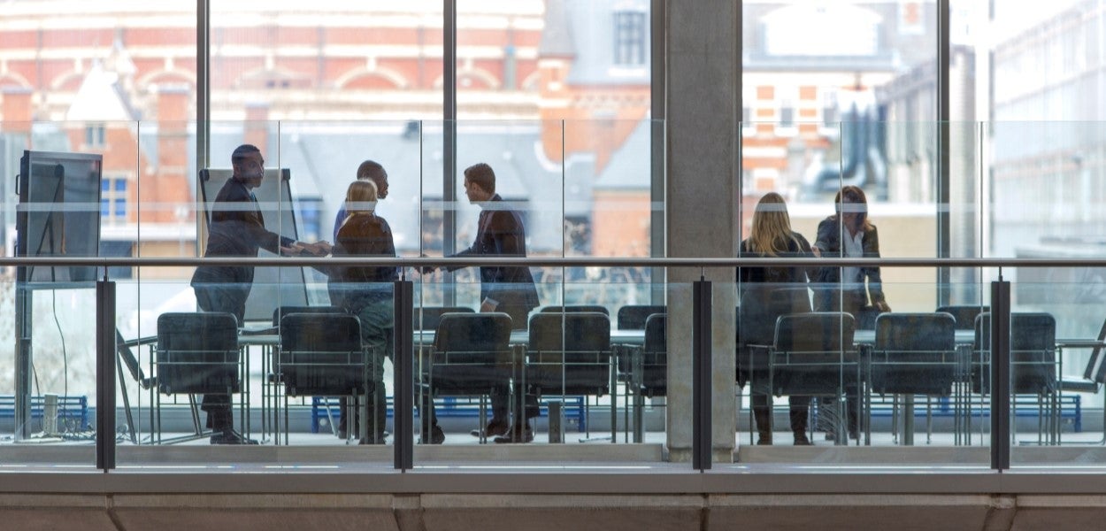 A group of people shaking hands in a meeting room.