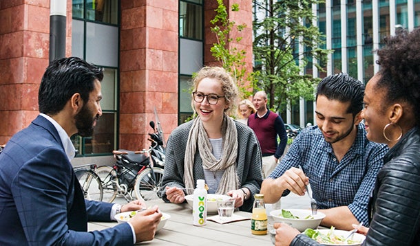 Studenten praten en lachen met elkaar op de campus