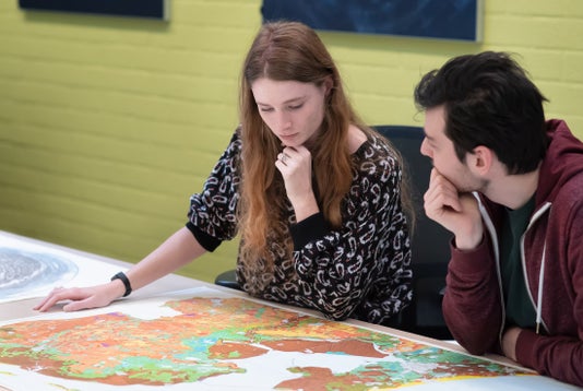 Twee studenten bekijken de kaartencollectie uit de Bijzondere Collecties van de UB (foto: Monique Kooijmans)