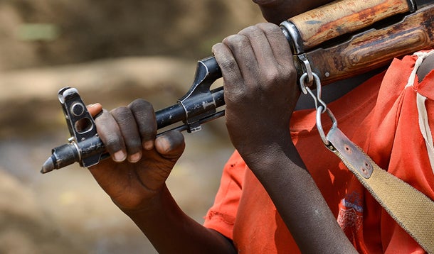 young boy walking with a gun