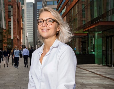 Student in front of office buildings at Zuidas