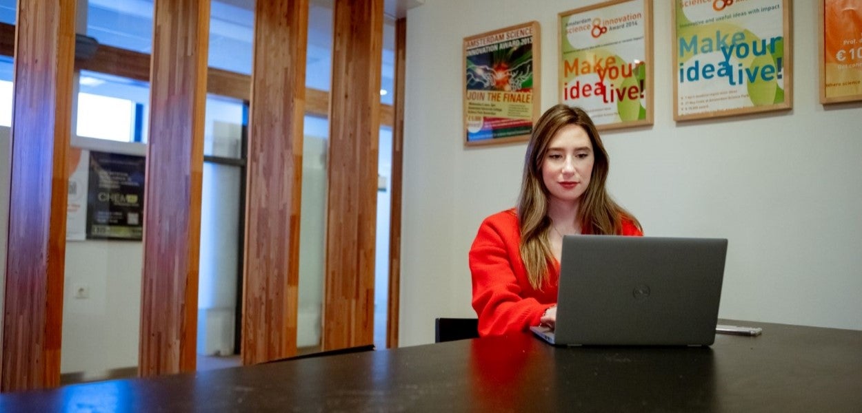 A woman at a table with a laptop.