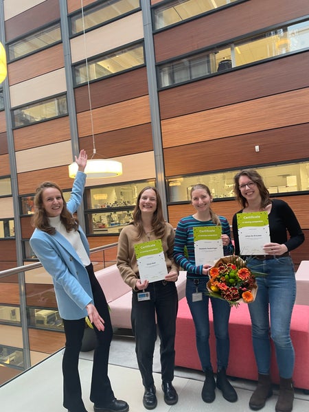 Marije van Beek (Mimetas, left) giving the MIMETAS prize to AIMMS' Elisabeth Naderlinger, Lenya de Brouwer and Olivia Klatt 