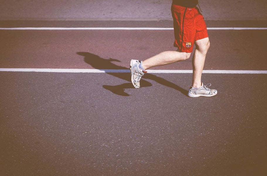 Een persoon rent op een atletiekbaan.