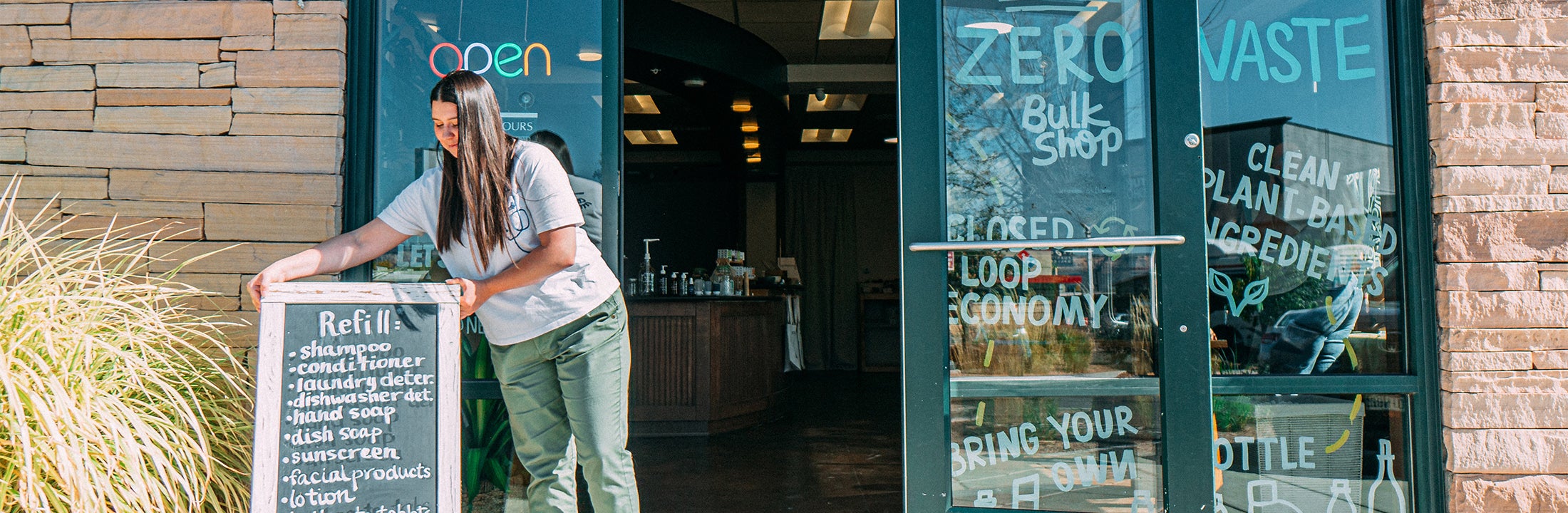 Young woman opening her shop with environmental friendly and healthy products.