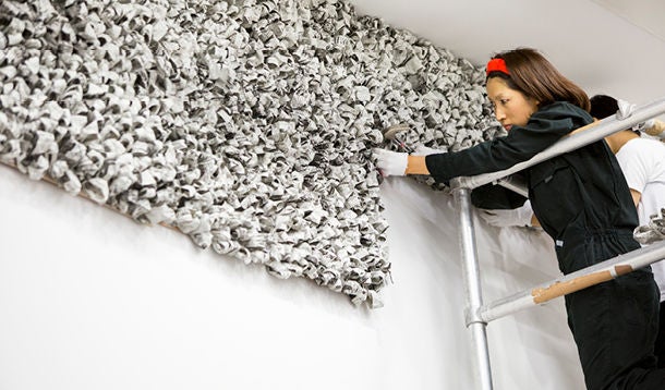  Woman stands on a scaffold and works on a work of art