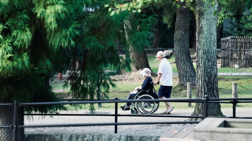A man pushing a woman in a wheelchair