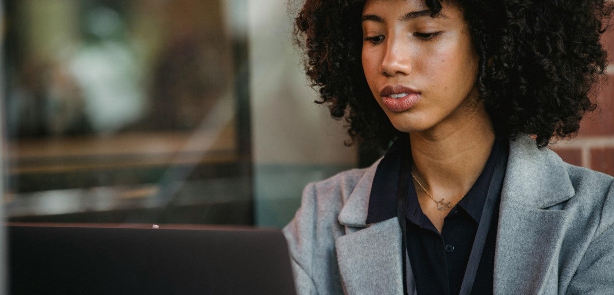 Een vrouw kijkt naar een laptop