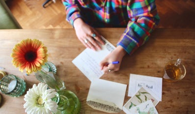 Someone is writing a letter at a table