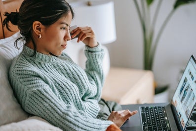 Student die op de bank op haar laptop zit