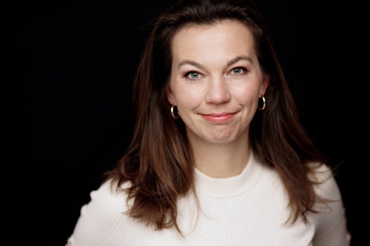 Een vrouw die voor de camera lacht