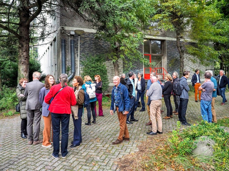 Mensen kijken naar de mozaïeken op het W&N-gebouw