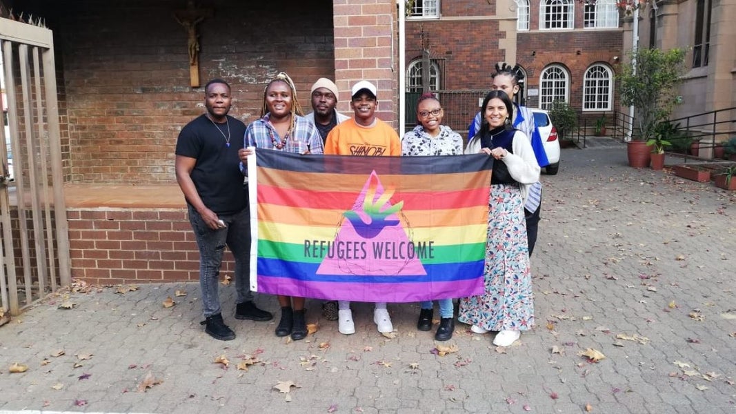 Group of people holding a flafwelcoming refugees