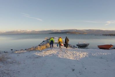 Three people walking towards water