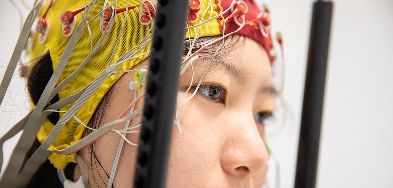 Een onderzoek in een labsituatie: de oogbewegingen van een proefpersoon worden gemeten met elektroden op de hoofdhuid (eyetracking en EEG). Foto door Peter Valckx, VU.