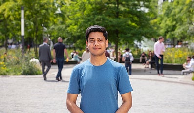 Student in a square with other people in the background