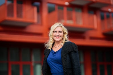A smiling woman in front of a building